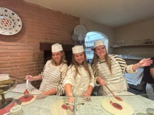college students making pizza in a pizza making class in florence italy
